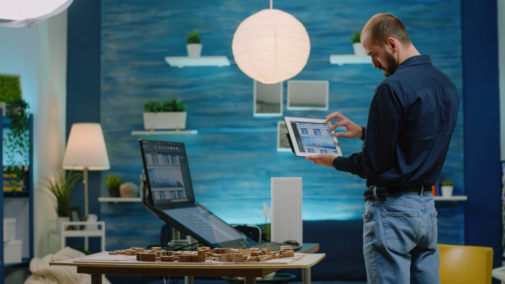 architect looking tablet with building model development man engineer holding gadget analyzing construction layout computer having maquette print plan table x