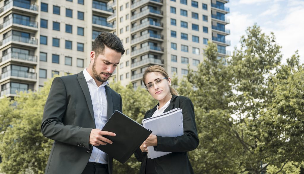 close up businessman businesswoman holding documents standing front building x