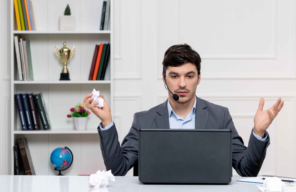 customer service cute guy grey suit with computer headset waving hands holding paper x